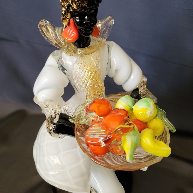 A Kneeling Blackamoor Murano Glass Venetian Woman holding a bowl of fruit and veggies.